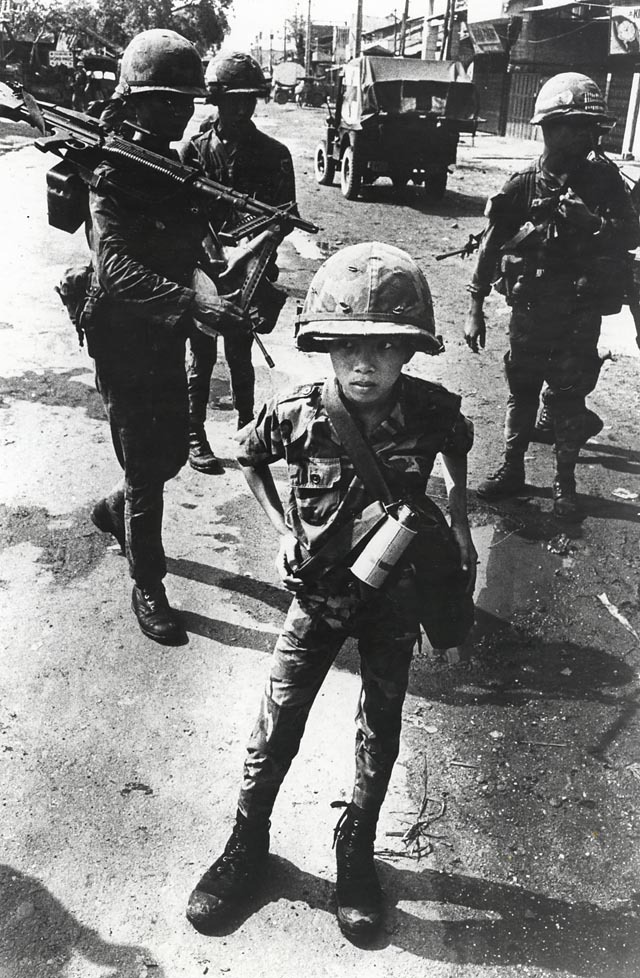 War / Photography: Images of Armed Conflict and Its Aftermath by Anne Wilkes Tucker, Will Michels and Natalie Zest (Yale University Press) - Philip Jones Griffiths, Welsh, 1936-2008, Called “Little Tiger” for killing two “Viet Cong women cadre”—his mother and teacher, it was rumored, Vietnam, 1968, Gelatin silver print, The Philip Jones Griffiths Foundation, courtesy of Howard Greenberg Gallery © Philip Jones Griffiths / Magnum Photos War / Photography: Images of Armed Conflict and Its Aftermath by Anne Wilkes Tucker, Will Michels and Natalie Zest (Yale University Press) - Philip Jones Griffiths, Welsh, 1936-2008, Called “Little Tiger” for killing two “Viet Cong women cadre”—his mother and teacher, it was rumored, Vietnam, 1968, Gelatin silver print, The Philip Jones Griffiths Foundation, courtesy of Howard Greenberg Gallery © Philip Jones Griffiths / Magnum Photos