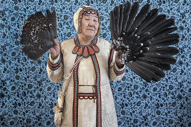 Nadejda, artisane de Khatystyr, tient des queues de grands tétras qu’elle a chassés ellemême. Les costumes Evenks s’inspirent de la nature, telle l’amulette à son cou qui reproduit la forme des plumes de cet oiseau. © Natalya Saprunova